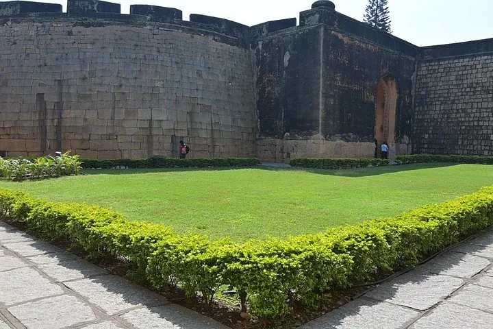 Grandes muros de piedra de un fuerte con un patio de césped